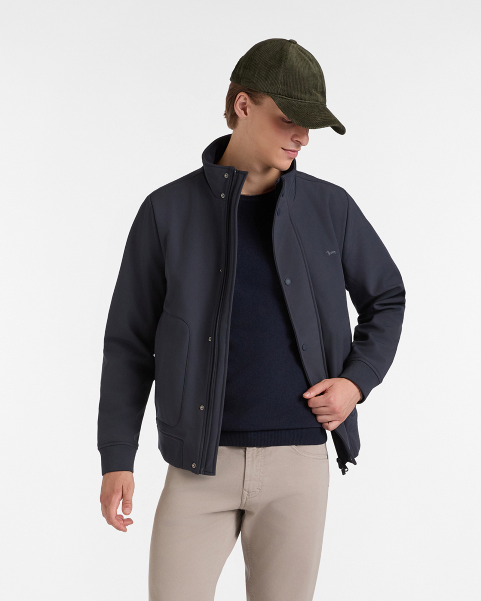 Man in dark blue casual jacket, blue sweater and green corduroy cap